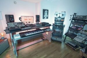 Muziekstudio met synthesizers, mengpanelen en monitoren