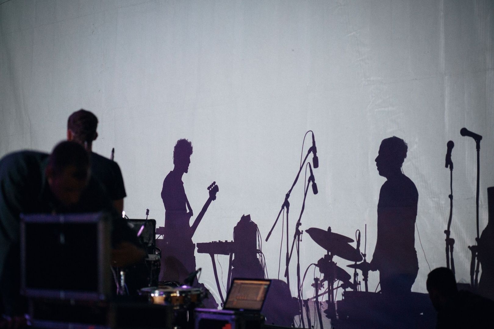 Silhouetten van muzikanten en microfoons tijdens een soundcheck op het podium