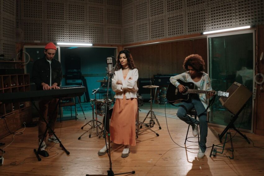Drie muzikanten repeteren samen in een opnamestudio